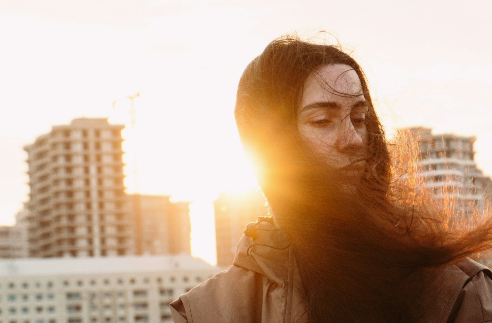 A woman looking calmly into the distance in warm evening light